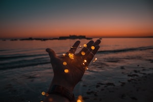 person with string lights on left hand