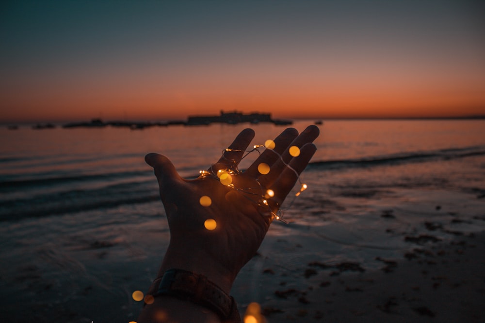 person with string lights on left hand