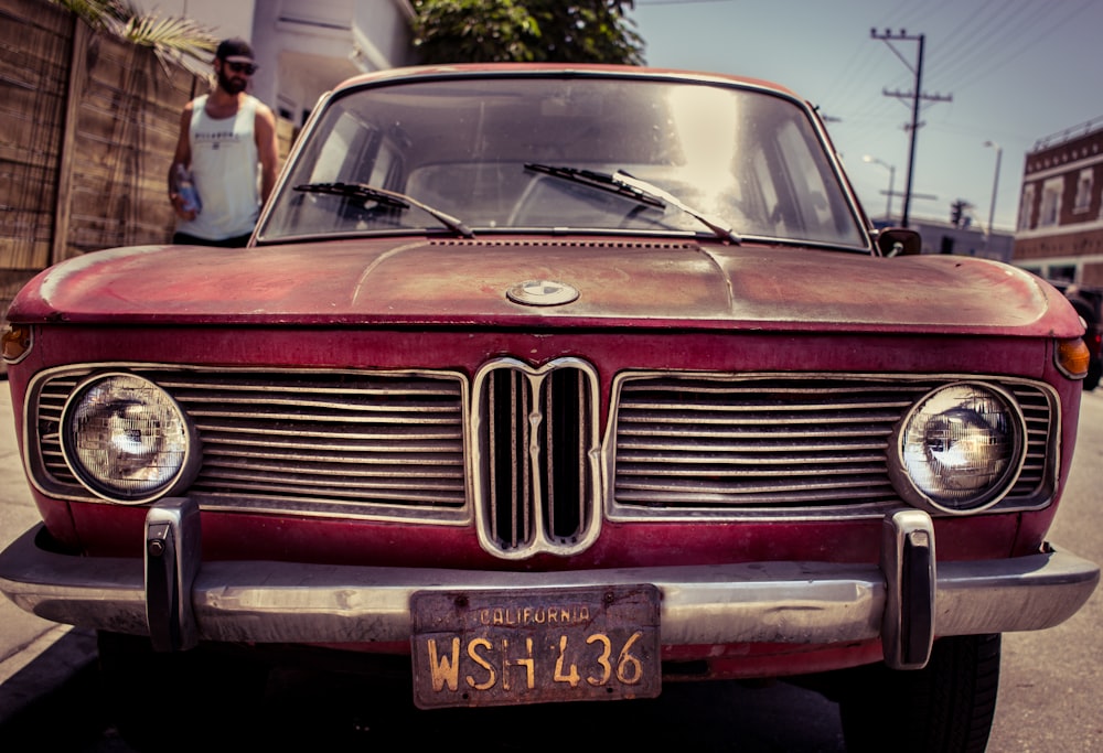 classic red car parked at sidewalk