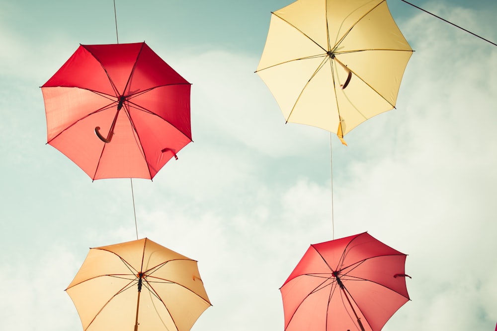 photo of four flying umbrellas on sky