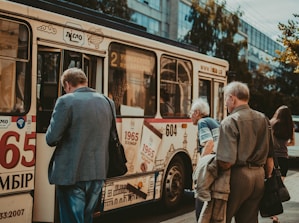 A group of diverse passengers boarding a spacious bus for intercity travel.
