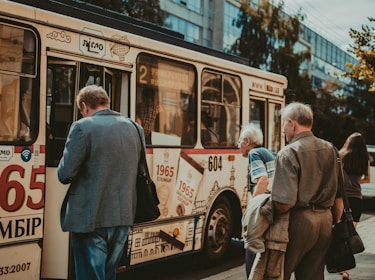 A group of diverse passengers boarding a spacious bus for intercity travel.