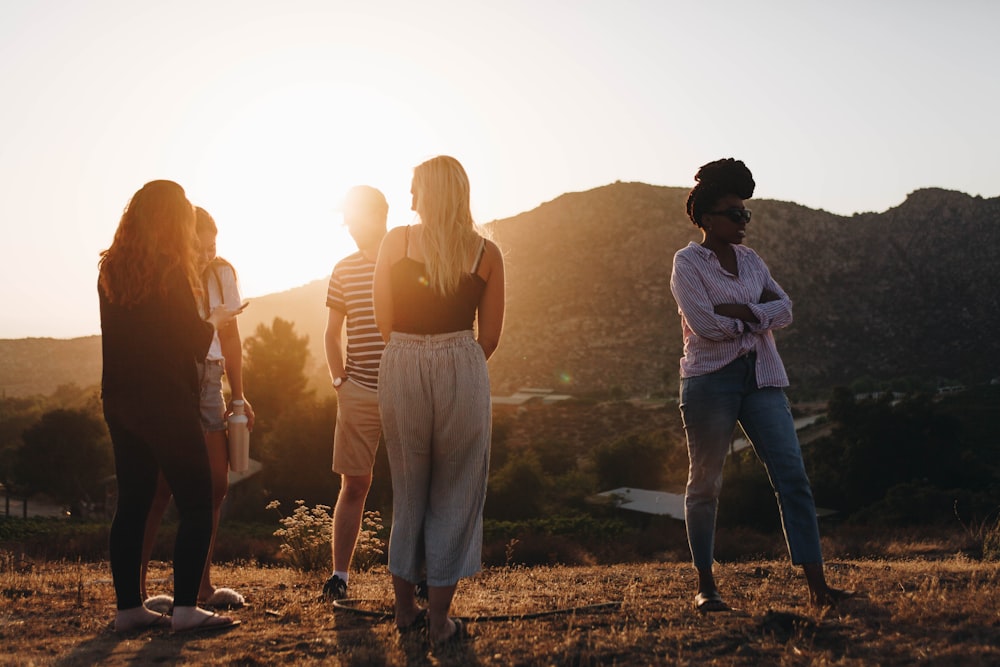 five person standing near mountain at golden hour