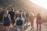 people walking on dirt road near mountain during daytime