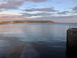 Wide shot of calm sea waters reflecting the soft evening light