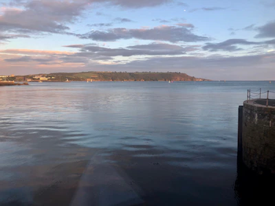 Wide shot of calm sea waters reflecting the soft evening light