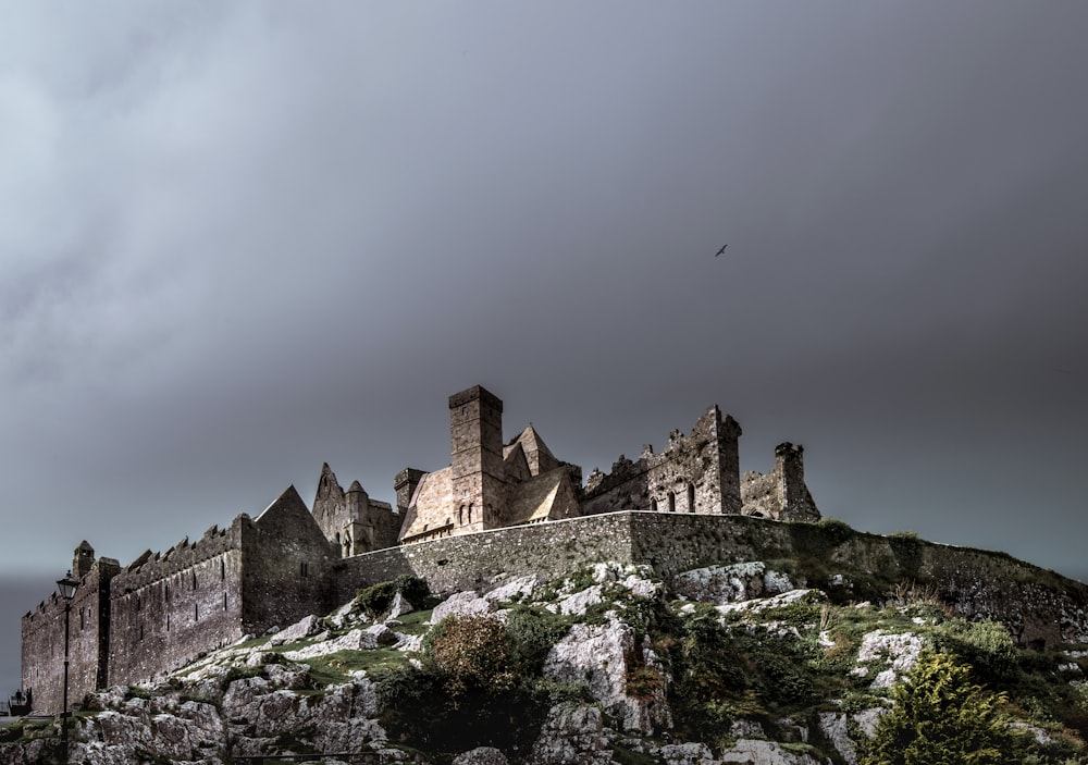 昼間の黒い雲の下の茶色のコンクリートの城