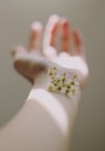selective focus photography of white clustered flowers on left human hand