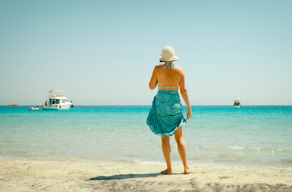 standing woman wearing green dress at shore during daytime