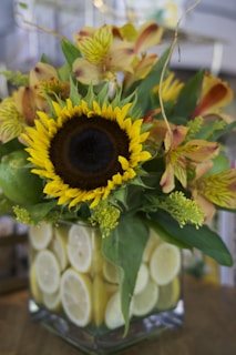A festive arrangement combining bright sunflowers and juicy citrus fruits in a woven basket.