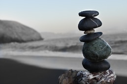 black rocks stacked on a beach