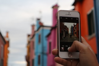 A photographer capturing a vibrant street scene with people and colorful buildings.