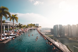 group of people at the swimming pool under white clouds