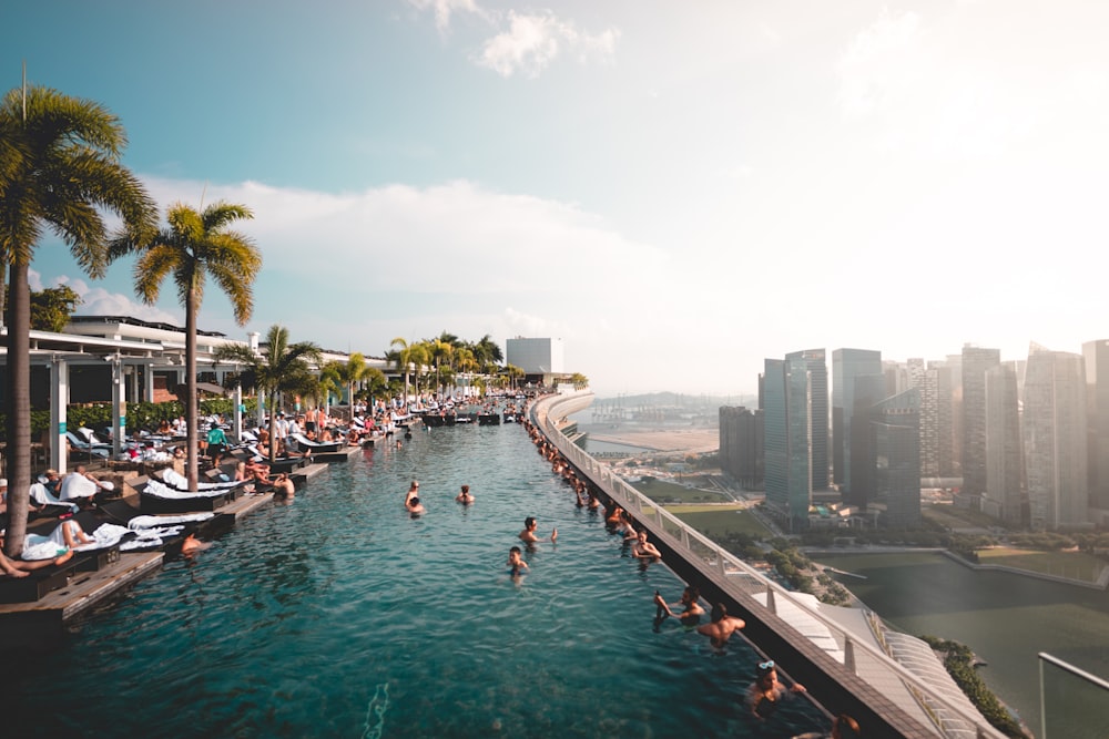 group of people at the swimming pool under white clouds