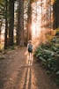 a woman walking down a path in the woods