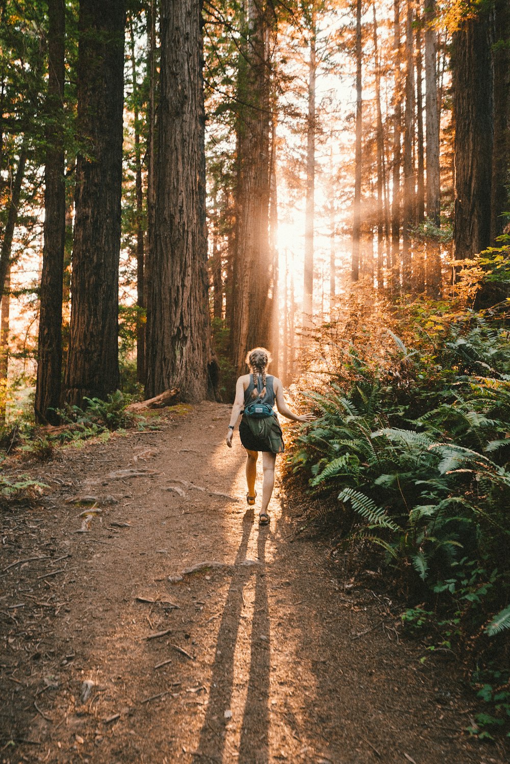 a woman walking down a path in the woods