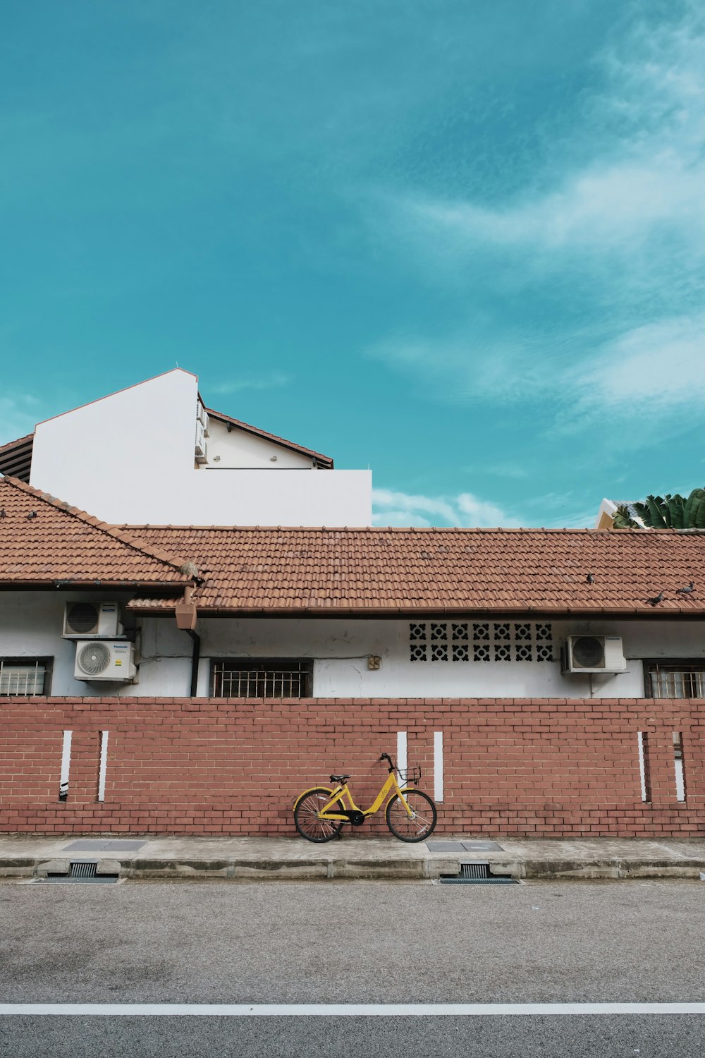 yellow bicycle in front on brown house