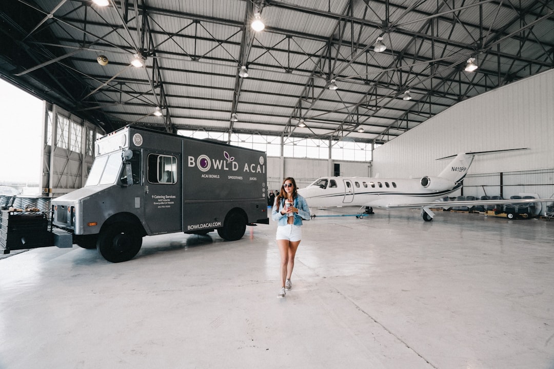 woman standing near white plane and vehicle