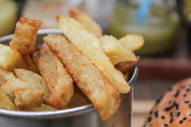Close-up of golden french fries being dispensed from a sleek vending machine.