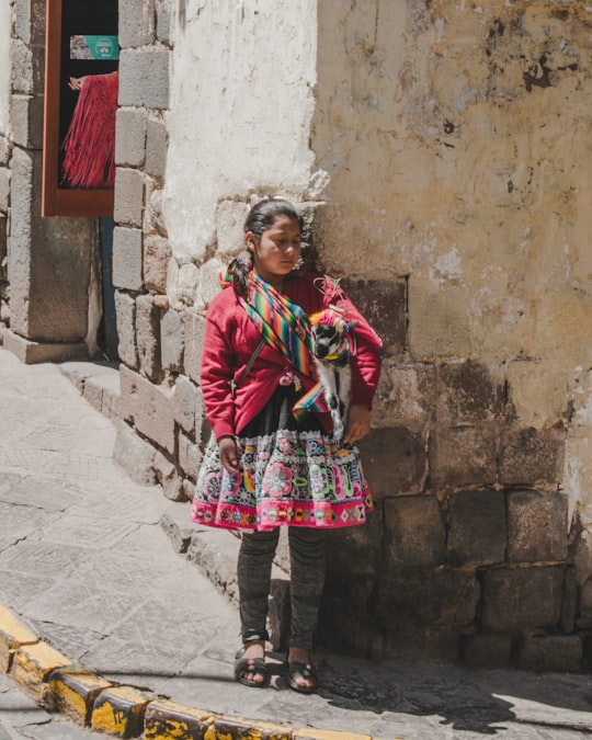 girl leaning on corner wall at daytime in Cusco Peru