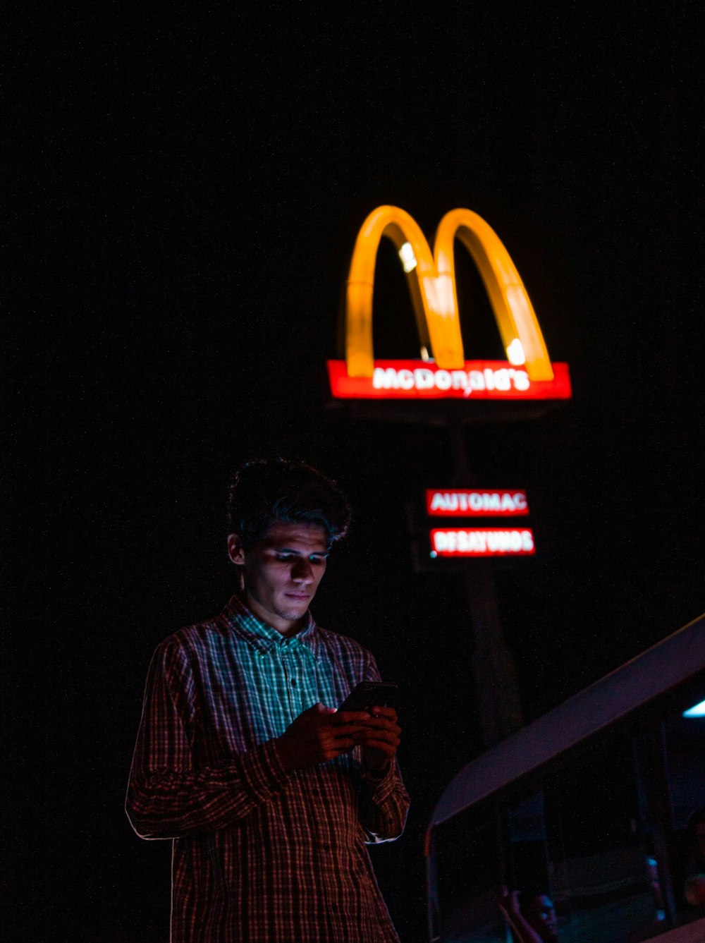 homme utilisant un smartphone Android près de McDonalds
