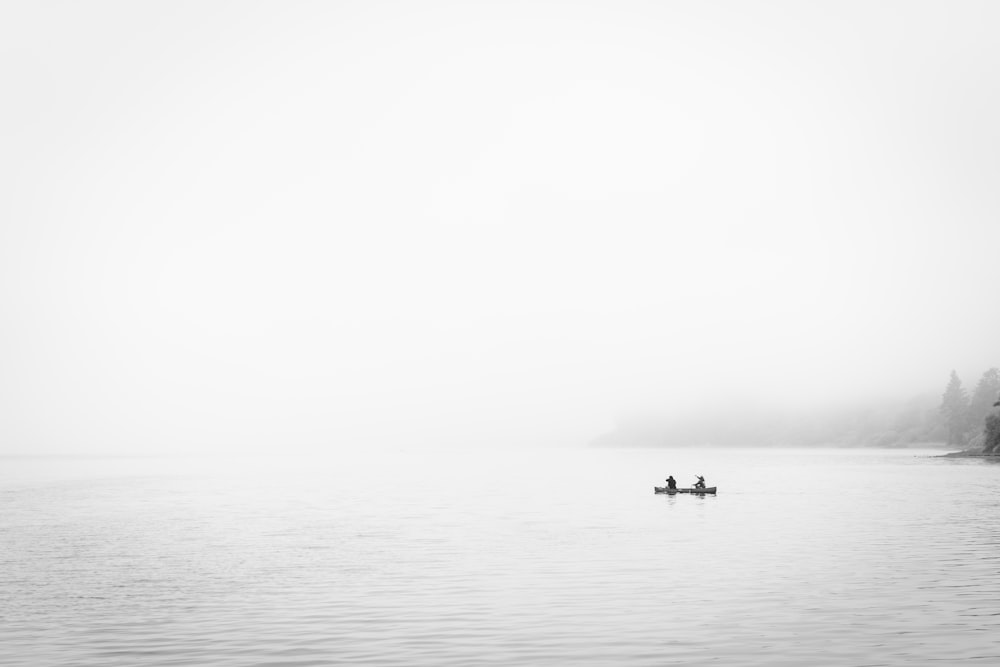 two person in boat on body of water