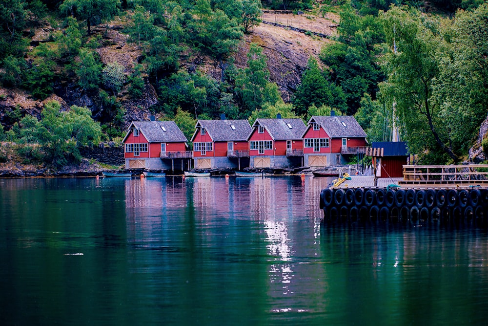 Quatro casas vermelhas e cinzentas à beira do lago