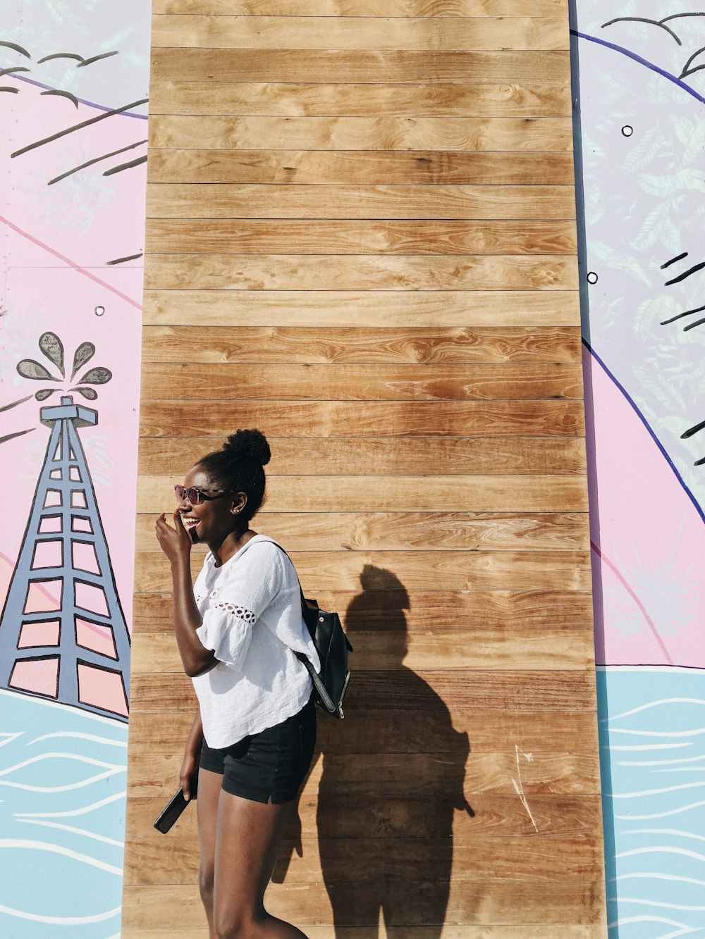 woman standing behind brown wall