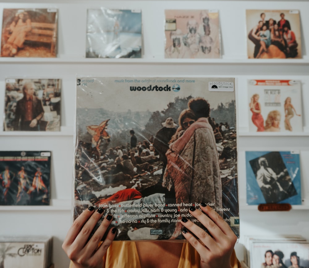 personne tenant le pack de pochettes de disques Woodstock