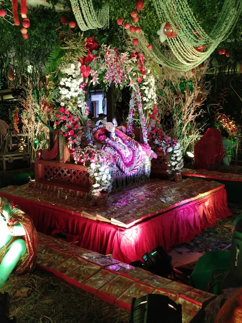 Elegant flower decorations arranged around a wedding altar, featuring natural greens and soft blooms.