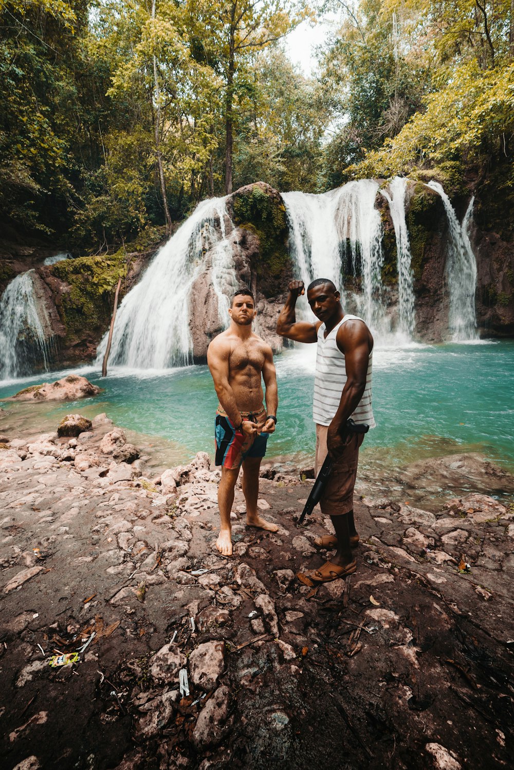 two man standing in front of the waterfalls during daytime