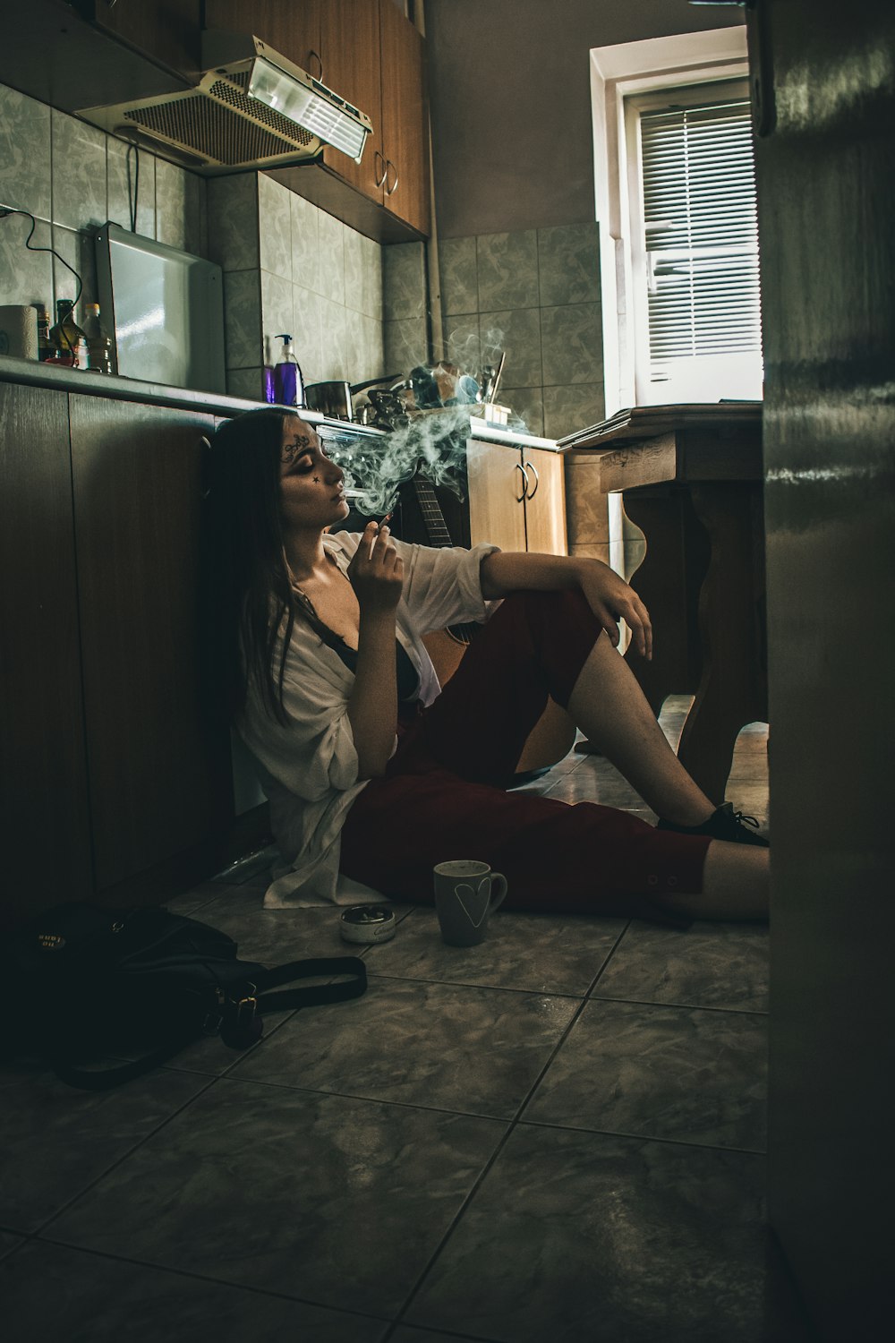 woman sitting on floor beside mug