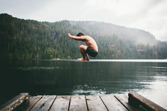 man jumping on body of water during daytime
