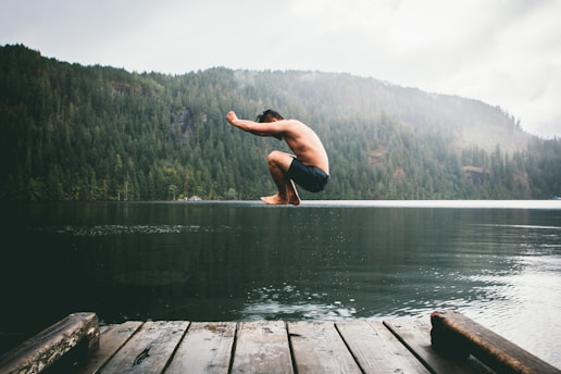 man jumping on body of water during daytime