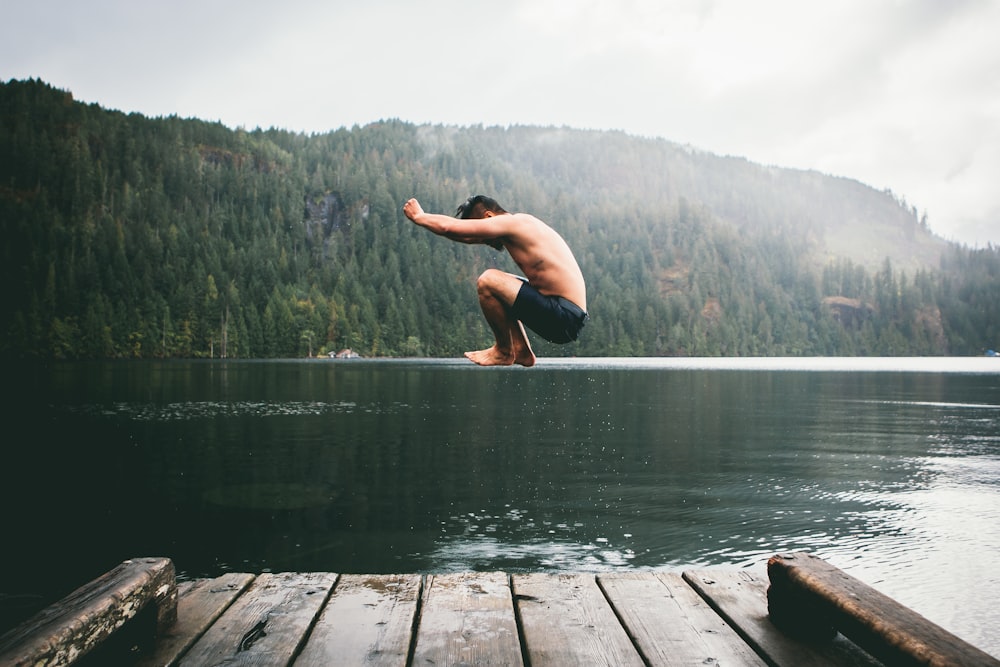 man jumping on body of water during daytime