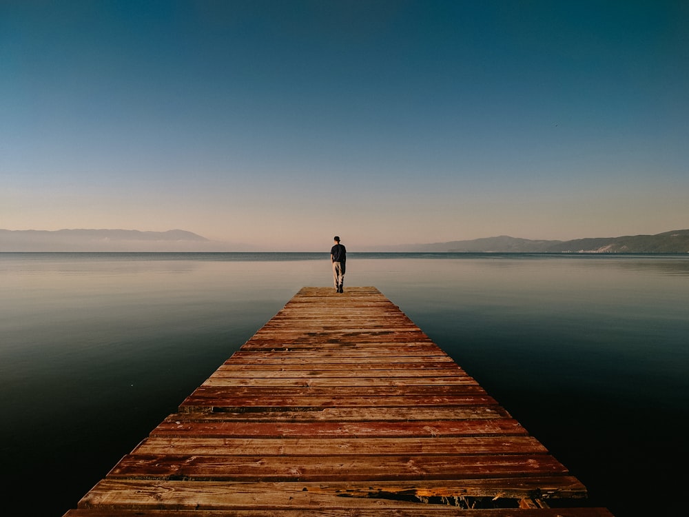 person on dock near body of water