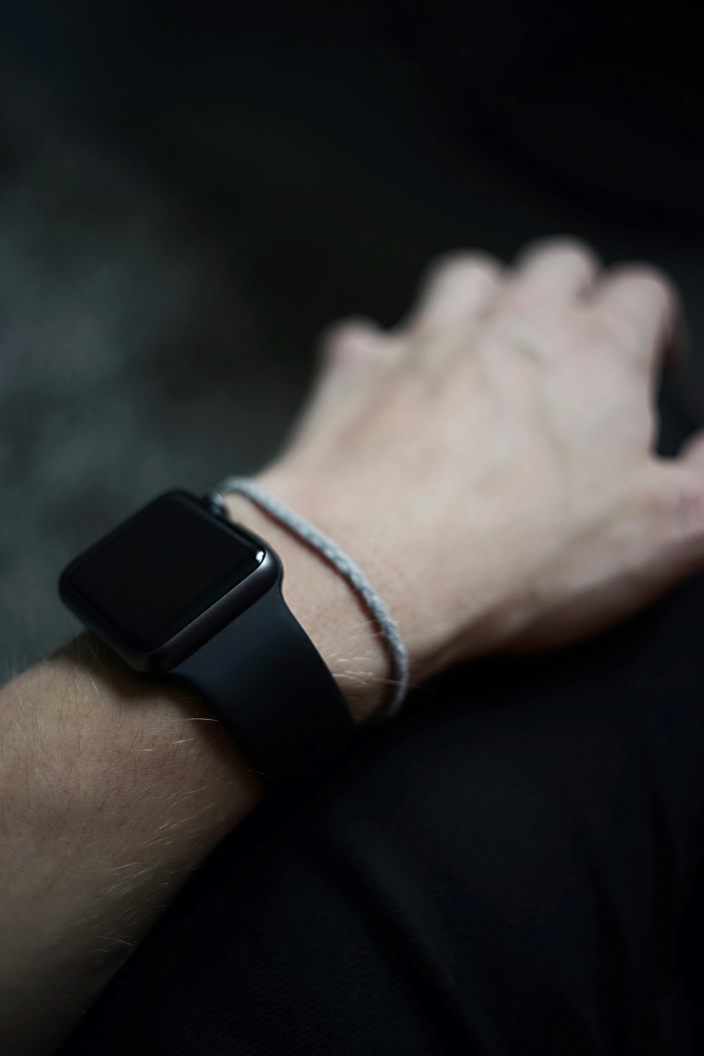 homem vestindo espaço cinza Apple Watch com preto Sports Band