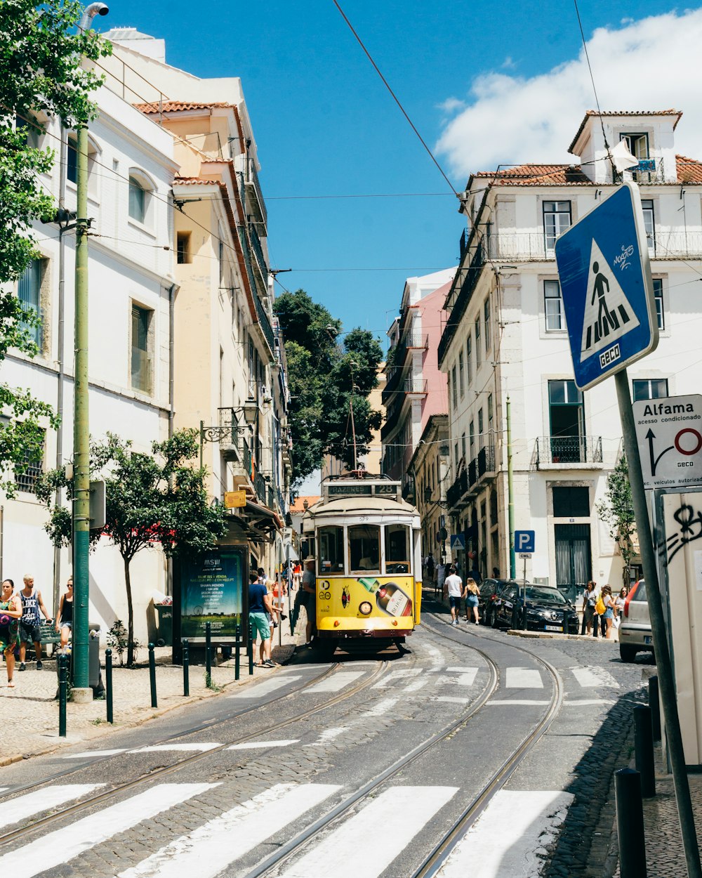 Train de tram jaune et marron près des gens