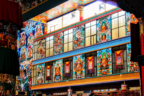Intricate mural depicting stories from sacred texts, painted in rich, warm colors inside the temple hall.