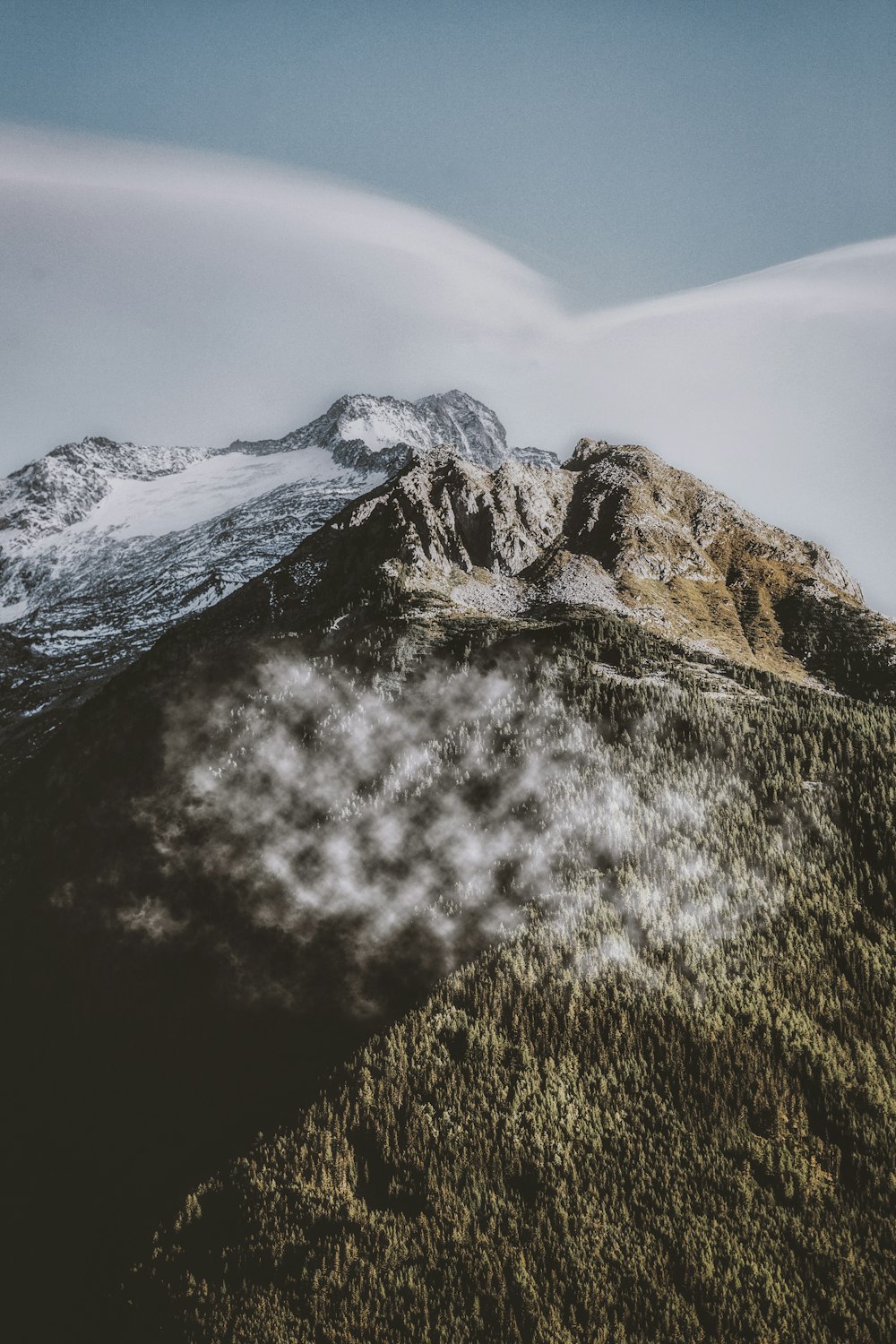 rock mountain under white clouds