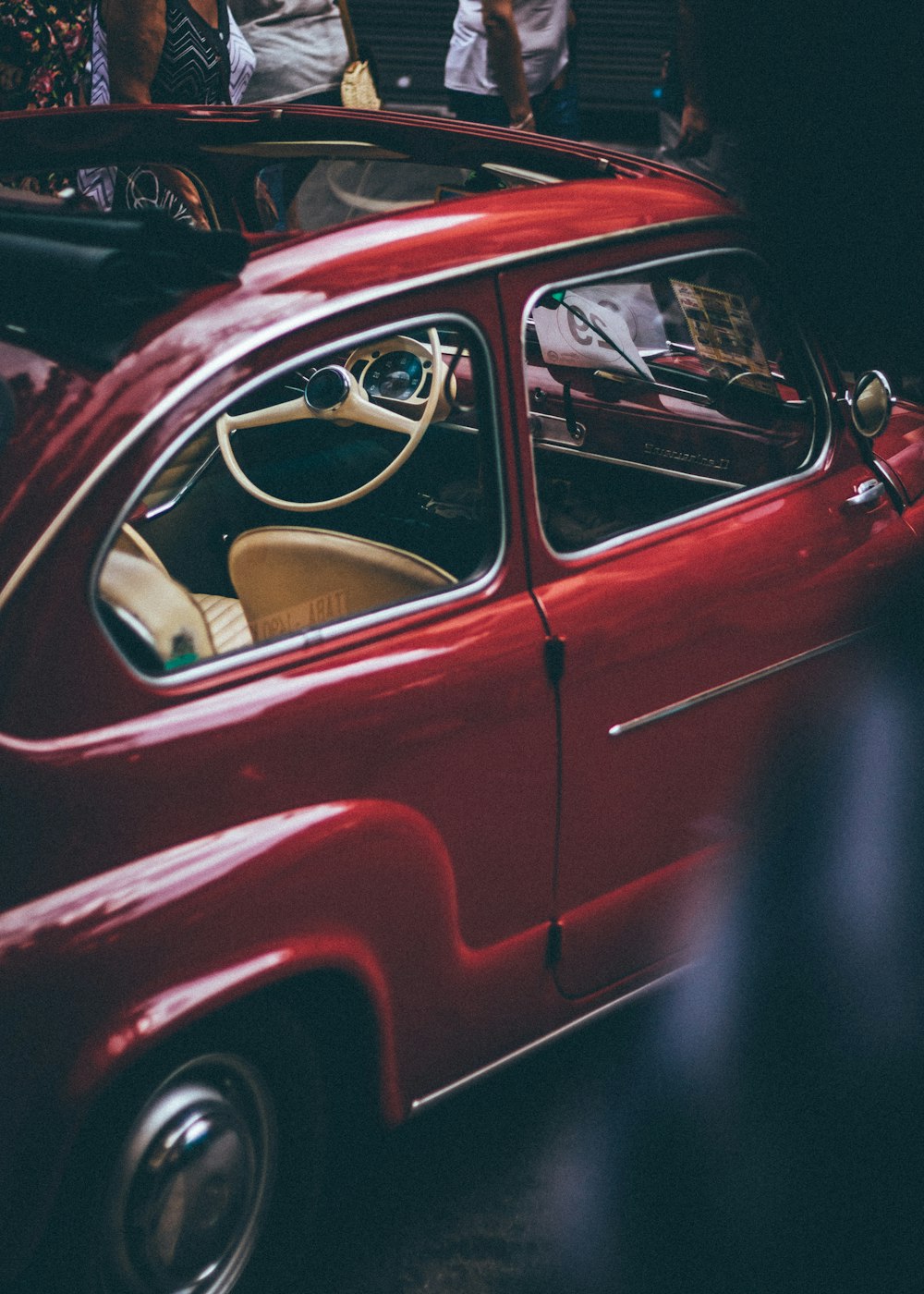 people surrounding red car