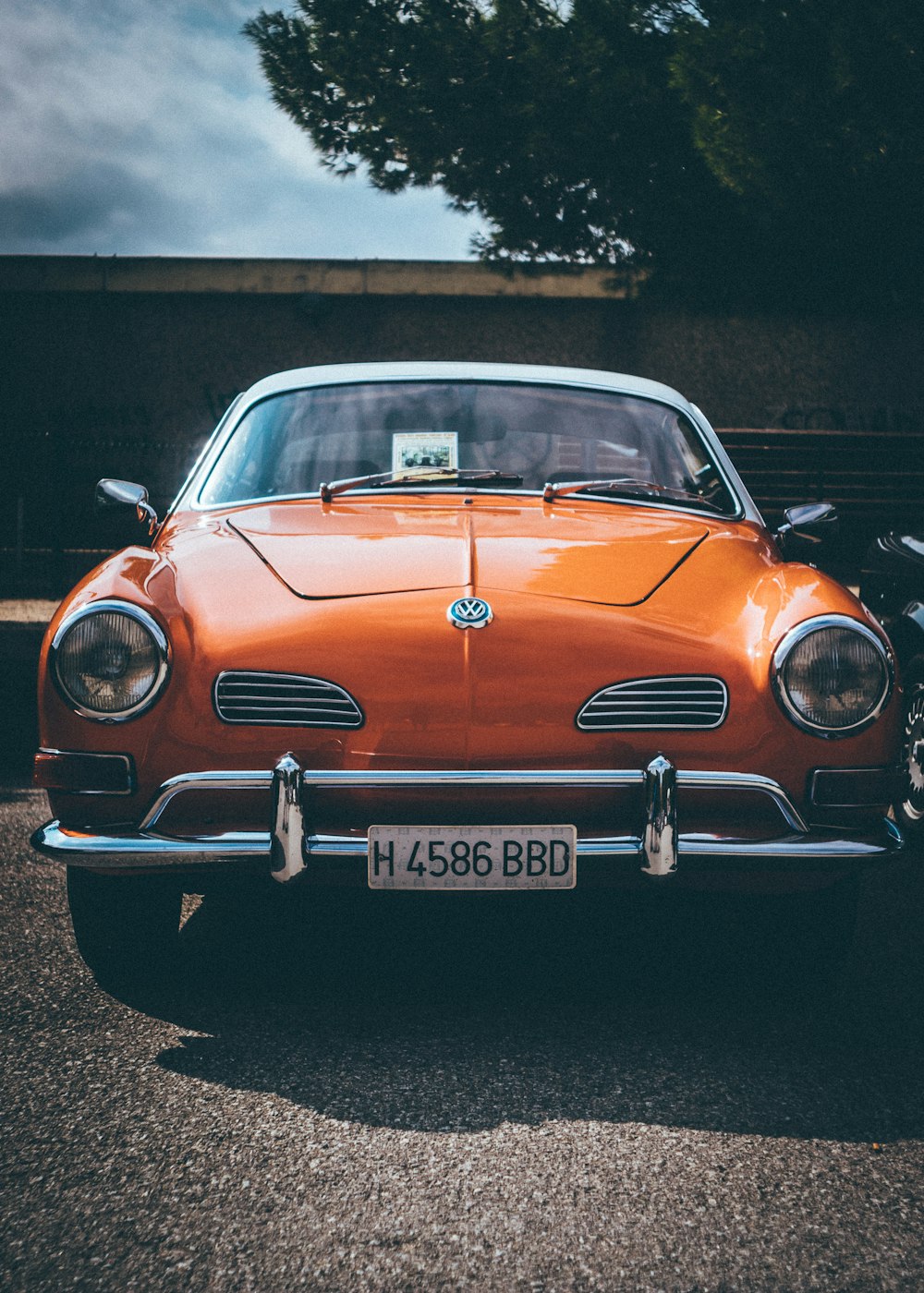 classic orange Volkswagen car parked in front of house