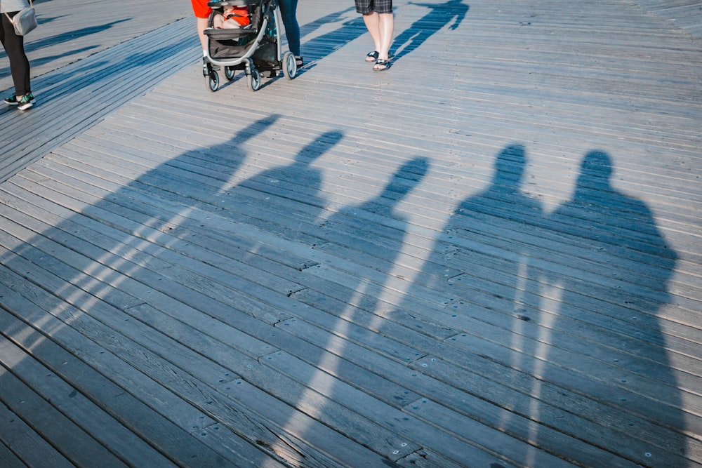 Fünf Menschen beschatten tagsüber in der Nähe eines schwarzen Kinderwagens