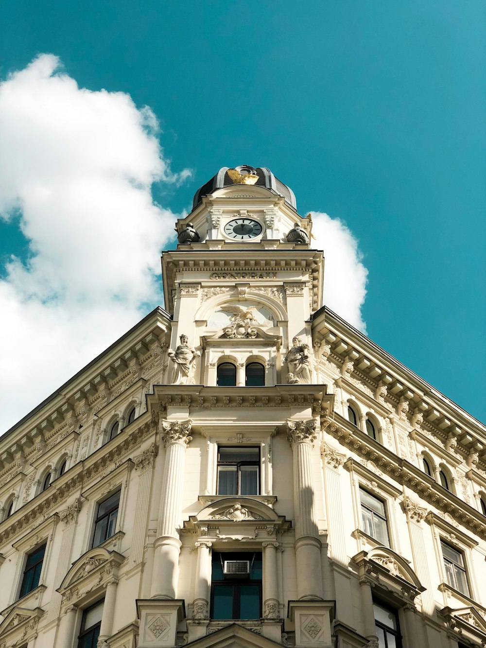 Weißes Betongebäude tagsüber unter blauem Himmel