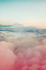 A serene blue sky blending into soft pastel clouds over a peaceful landscape.