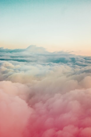 A serene blue sky blending into soft pastel clouds over a peaceful landscape.
