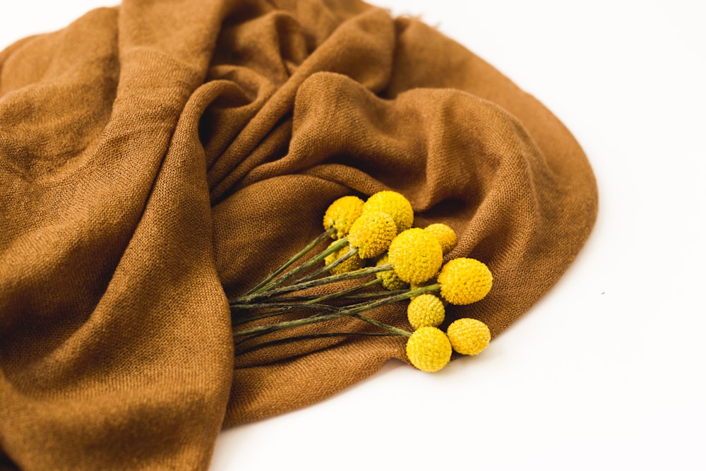 yellow flowers on brown textile