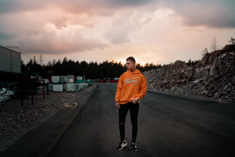 men's orange pullover hoodie and black pants