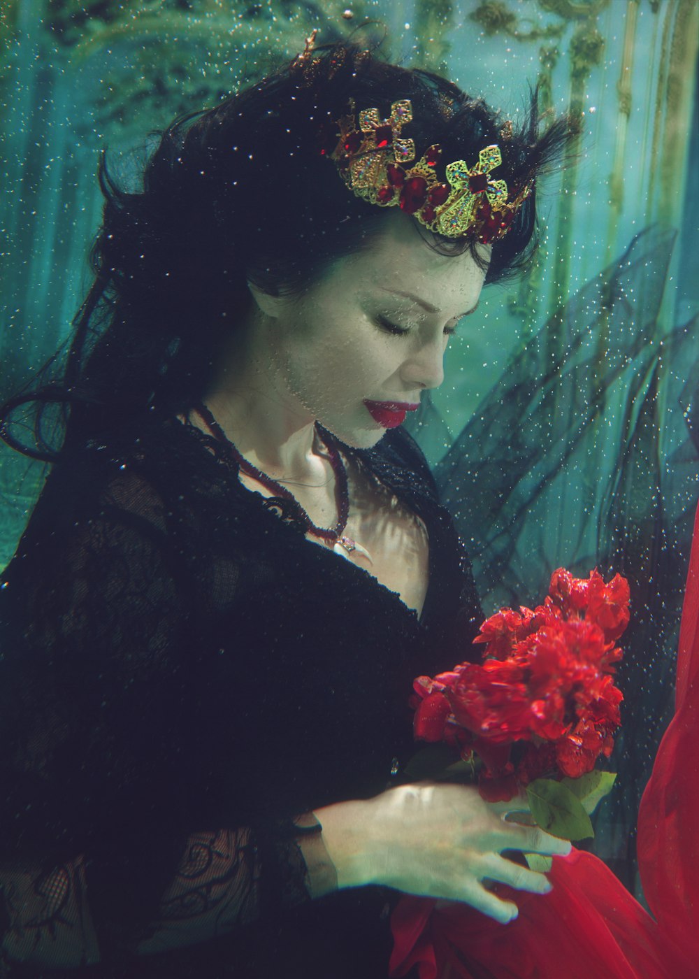 femme tenant une fleur rouge