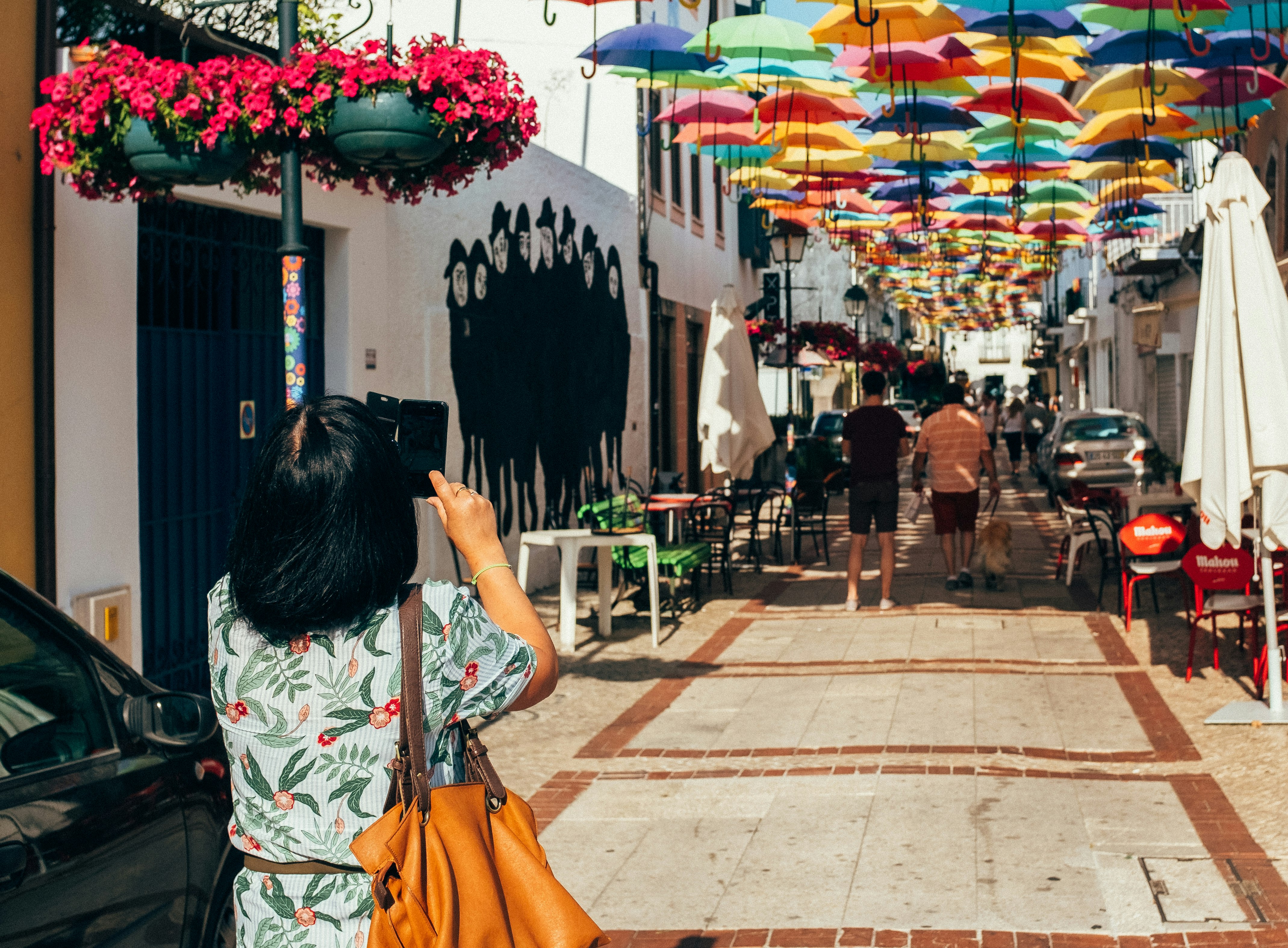 woman taking photo of umbrella roofs